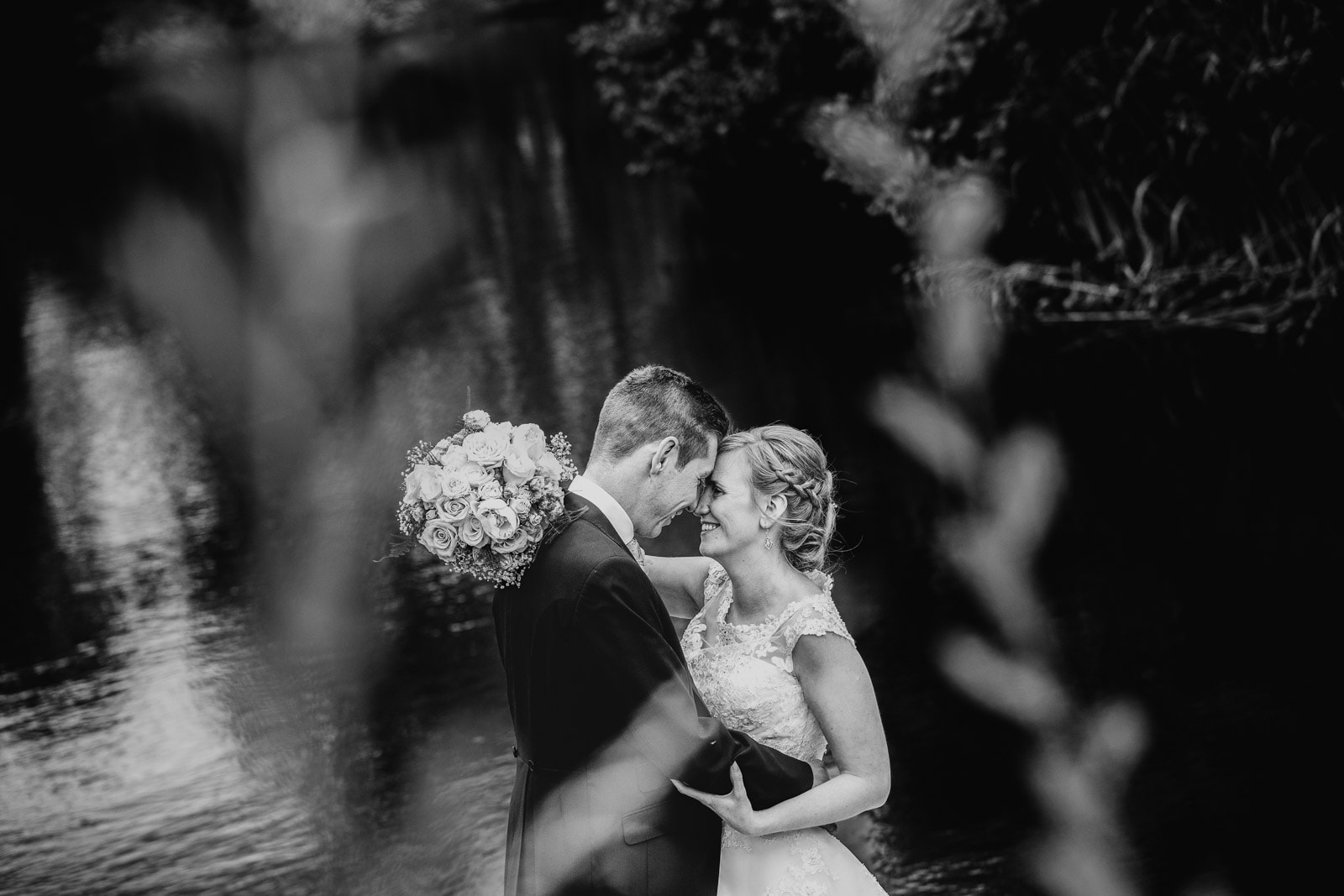 Bride and groom by the lake at styal lodge wedding venue