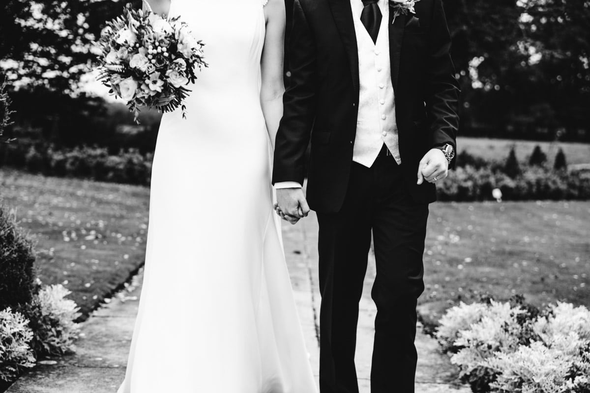 bride and groom holding hands at thornton hall hotel
