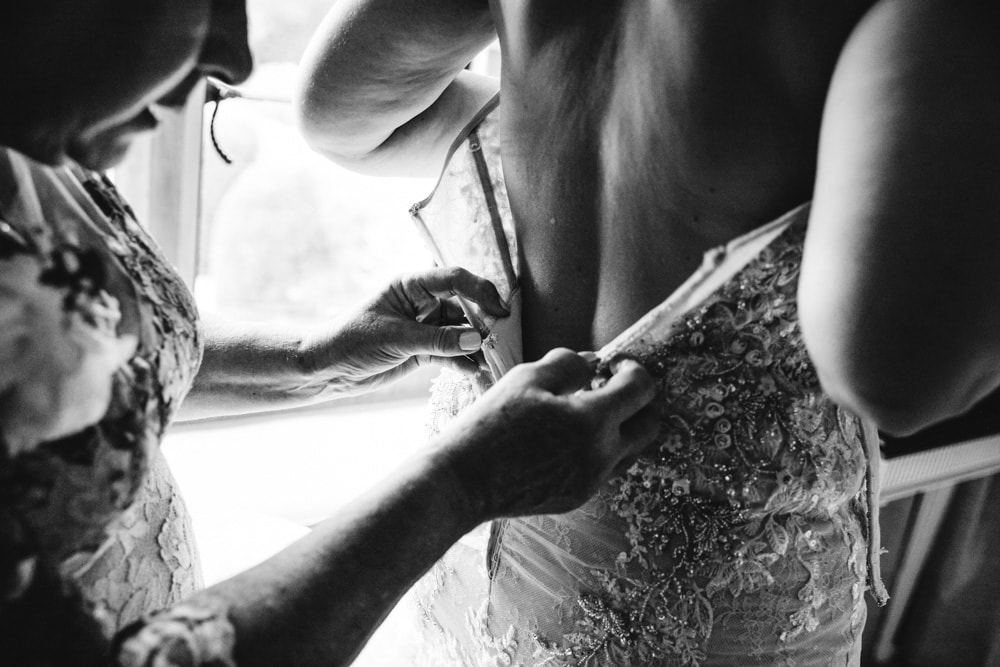 bride getting into her wedding dress at soughton hall