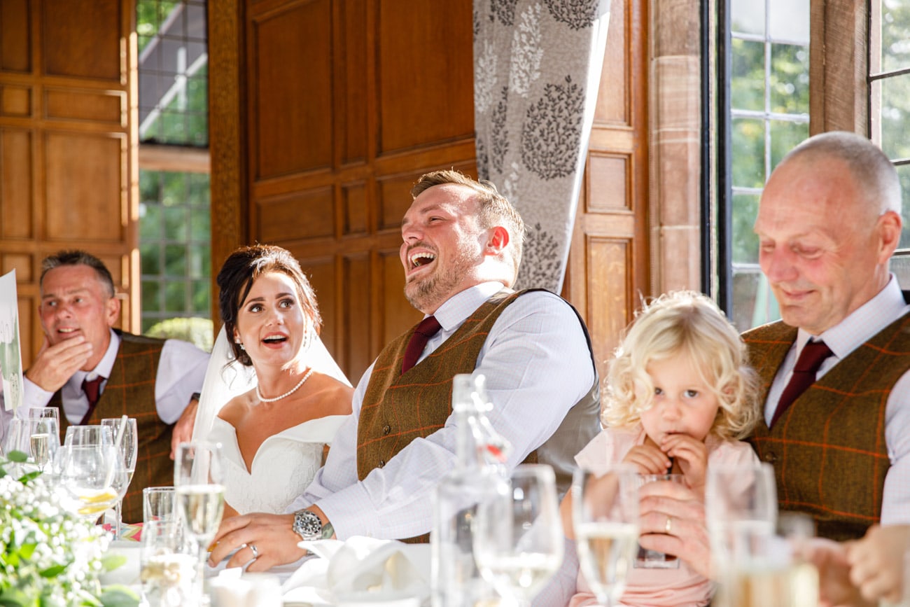 groom laughing during wedding speech