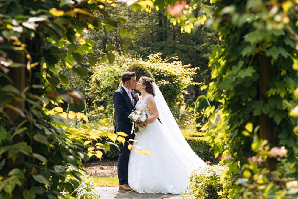 a bride and groom in the gardens at mottram hall