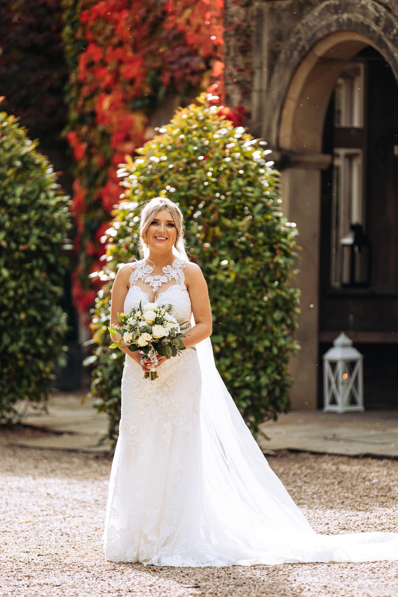 bride at the front of mitton hall in her wedding dress