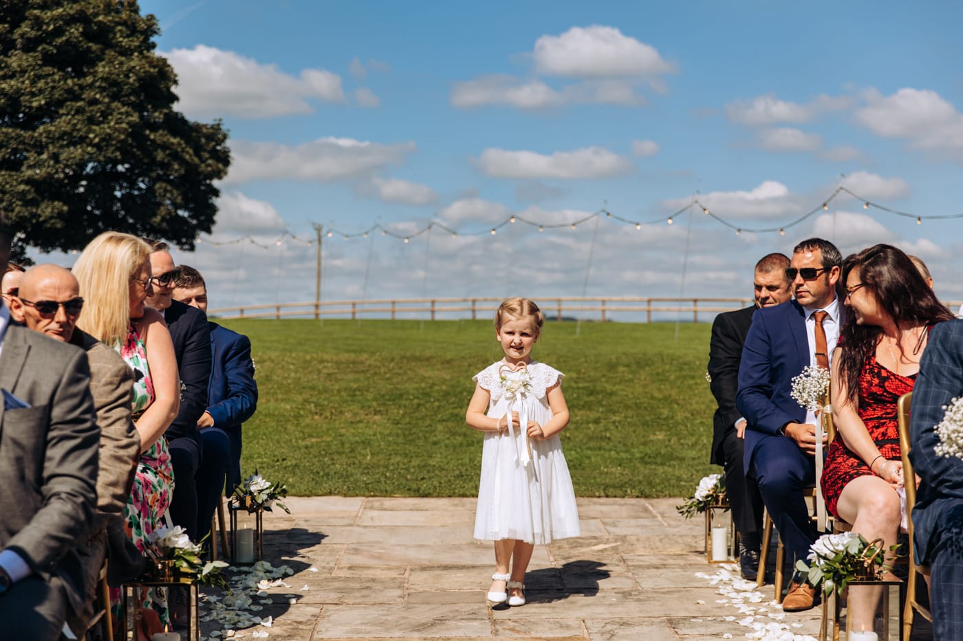 an outdoor ceremony with the bride walking down the aisle to get married at heaton house farm
