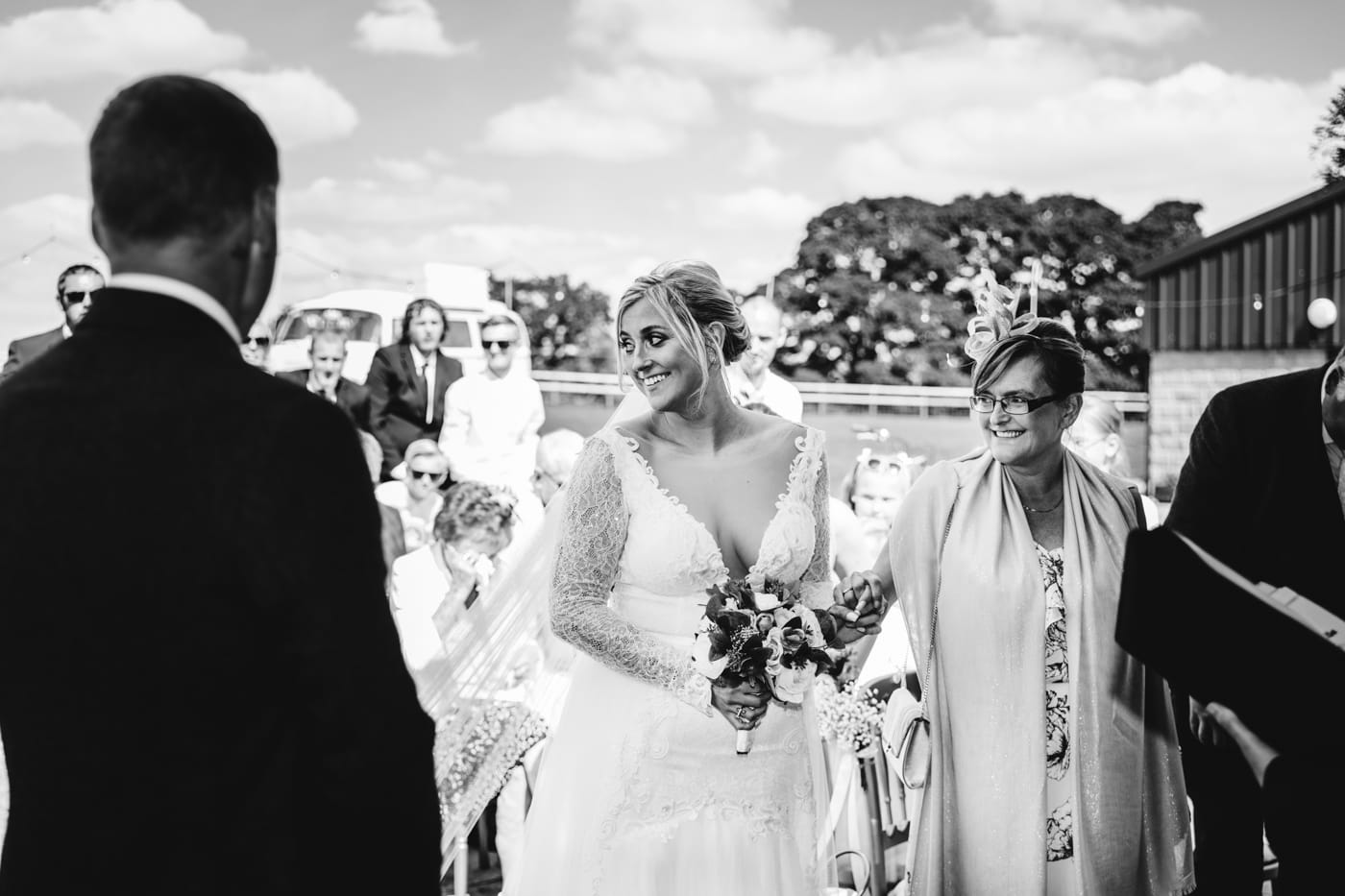 an outdoor ceremony with the bride walking down the aisle to get married at heaton house farm