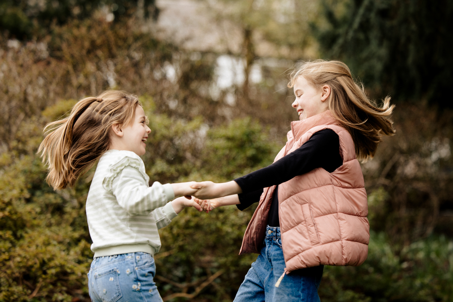 Family portrait photographers a photograph of 2 siblings enjoying being spun around in a natural way