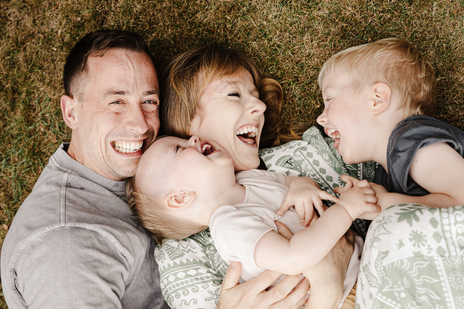 kids laughing on the grass during a fun family photoshoot session with ER Photography